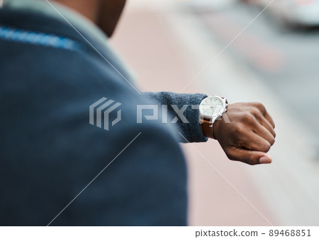 Never underestimate the value of time. Cropped shot of a businessman checking the time against an urban background. Never underestimate the value of time. Cropped shot of a businessman checking the time against an urban background. 89468851