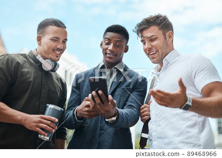 Making moves all over the city. Shot of a group of businesspeople using a smartphone together against an urban background. 89468966