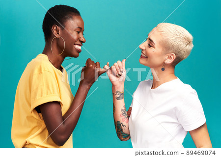 You can count on me. Studio shot of two young women linking their fingers against a turquoise background. 89469074