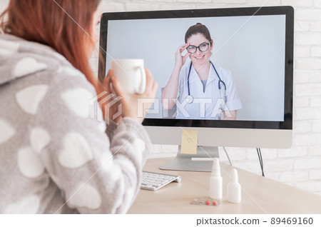 A woman with a respiratory illness is quarantined and is talking to a GP on a webcam. A doctor for an online consultation for a sick patient. 89469160