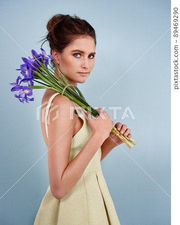 Looking lovely with lavender. Cropped shot of an attractive young woman holding flowers against a gray background. 89469290