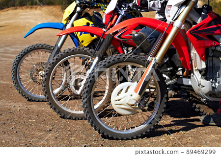 Built for tough terrain. Three dirt bikes standing in a row. 89469299
