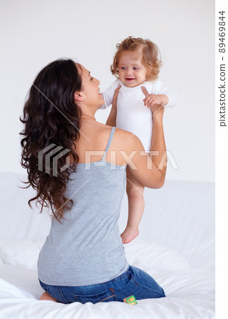 My gorgeous little angel. Rearview shot of a mother holding up her baby daughter. 89469844