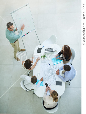 Presenting his new business model. High angle shot of a businessman giving a presentation in the office. 89469867
