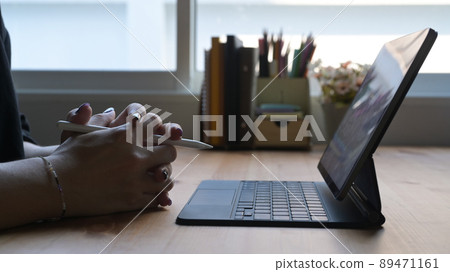 Young woman studying online, watching webinar on computer tablet. Close up view. Young woman studying online, watching webinar on computer tablet. Close up view. 89471161