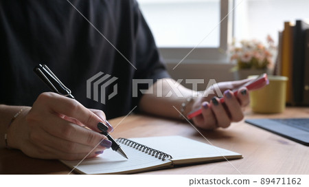 Close up stylish man hand writing on notebook and using mobile phone at home office desk. Close up stylish man hand writing on notebook and using mobile phone at home office desk. 89471162