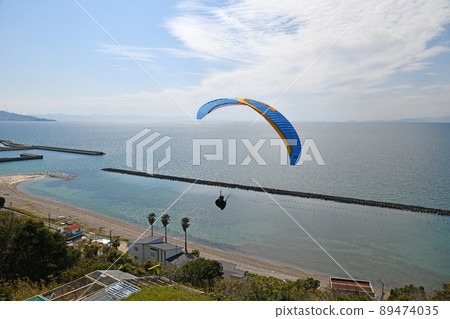 Paraglider going over the sea 89474035