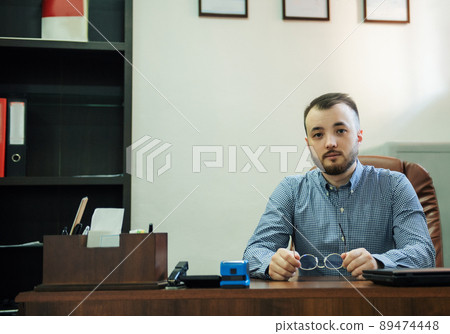 Businessman working on his laptop in an office Businessman working on his laptop in an office 89474448