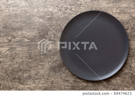 Top view of black plate on wooden background. Empty space for your design 89474623