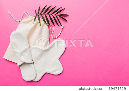 lean feminine sanitary napkin with green leaf. Absence of menstruation in woman. Minimal concept of female menopause. Copy space top view 89475529