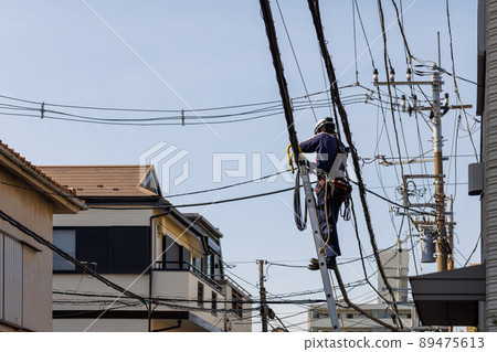Workers working on electric wires in the city 89475613