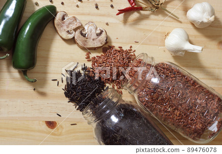 Jars of Red and Wild Rice on Rustic Table With Peppers and Spices Ingredients for Cooking 89476078