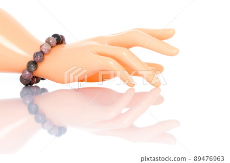 Rhodonite bracelet on plastic mannequin female hand. Collection of natural gemstones accessories. Studio shot 89476963