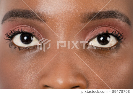 Close up, profle photo of a dark skin female eye, iris, pupil, eye lashes, eye lids. 89478708