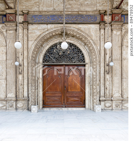 Wooden ornate door over white marble decorated wall. One of the entrances of the Mosque of Muhammad Ali Pasha, Citadel of Cairo, Egypt Wooden ornate door over white marble decorated wall. One of the entrances of the Mosque of Muhammad Ali Pasha, Citadel of Cairo, Egypt 89478932