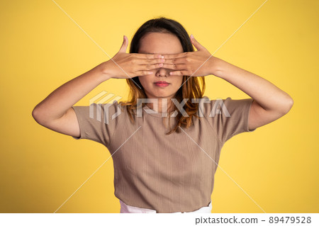 woman closing eyes with both palms on isolated background 89479528