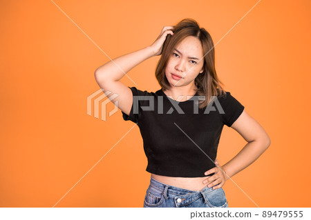 Thoughtful Asian woman poses against isolated background 89479555