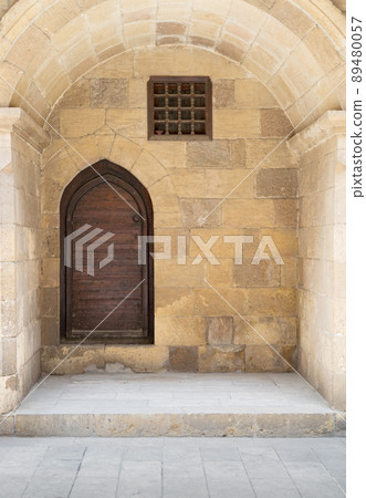 Wooden aged vaulted ornate in a recessed stone wall, Medieval Cairo, Egypt 89480057