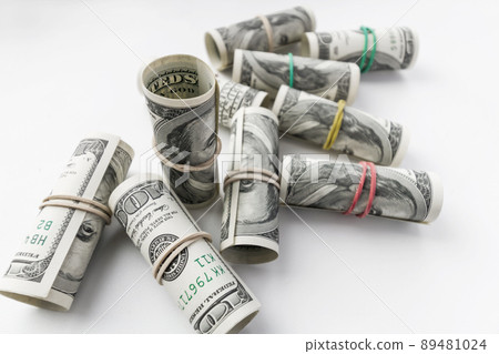 American one hundred dollar banknotes rolled up as a tubule. Light background, closeup, selective focus American one hundred dollar banknotes rolled up as a tubule. Light background, closeup, selective focus 89481024
