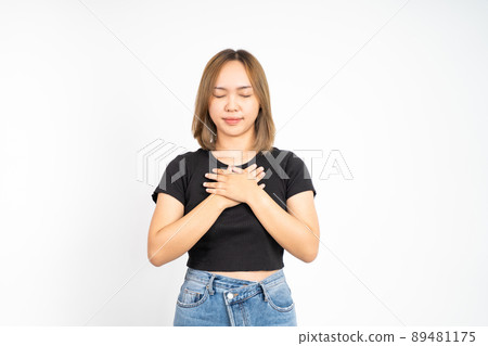Asian young woman holding chest while feeling relieved 89481175