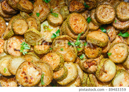 Background of fried zucchini with herbs. 89483359
