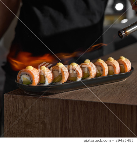 Restaurant Chef cook preparing salmon filet flambe in open kitchen Restaurant Chef cook preparing salmon filet flambe in open kitchen 89485495