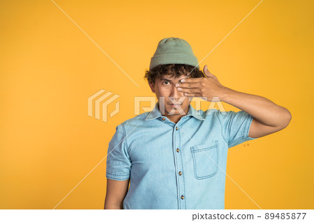 man with hands covering eyes standing with isolated background man with hands covering eyes standing with isolated background 89485877