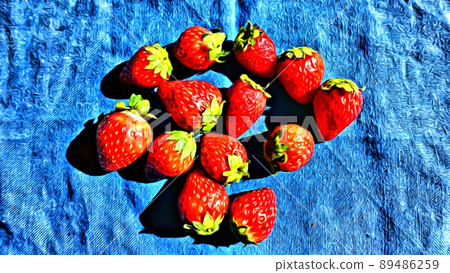 Freshly picked strawberries spread out on a blue towel. 89486259