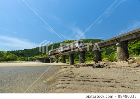 JR Kyushu Nichinan Line Local Limited Express Umisachi Yamasachi running on the Kumagaya River Bridge in Sanno, Nichinan City, Miyazaki Prefecture, where the clear blue sky spreads on the Nichinan coast 89486335