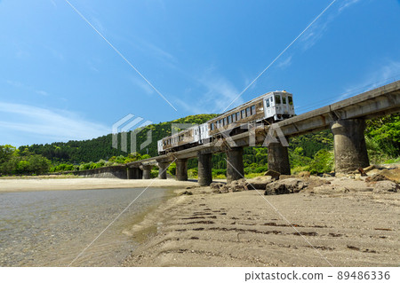 JR九州日南線地方特快海幸山幸行駛在宮崎縣日南市山王的熊谷川大橋上，在日南海岸上鋪滿了湛藍的天空 89486336