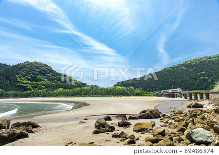 JR九州日南線地方特快海幸山幸行駛在宮崎縣日南市山王的熊谷川大橋上，在日南海岸上鋪滿了湛藍的天空 89486374