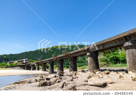 JR Kyushu Nichinan Line Local Limited Express Umisachi Yamasachi running on the Kumagaya River Bridge in Sanno, Nichinan City, Miyazaki Prefecture, where the clear blue sky spreads on the Nichinan coast 89486549