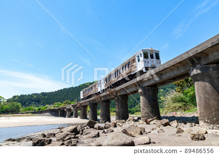JR Kyushu Nichinan Line Local Limited Express Umisachi Yamasachi running on the Kumagaya River Bridge in Sanno, Nichinan City, Miyazaki Prefecture, where the clear blue sky spreads on the Nichinan coast JR Kyushu Nichinan Line Local Limited Express Umisachi Yamasachi running on the Kumagaya River Bridge in Sanno, Nichinan City, Miyazaki Prefecture, where the clear blue sky spreads on the Nichinan coast 89486556