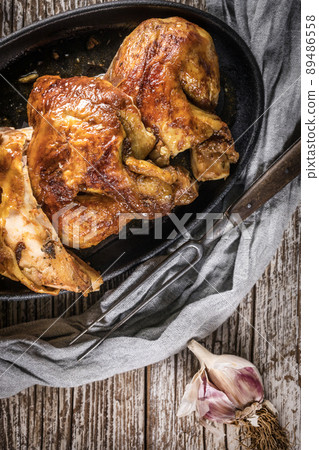 Quarters of fried chicken in a cast iron skillet. Quarters of fried chicken in a cast iron skillet. 89486558