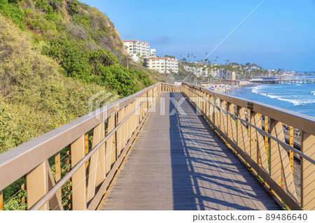 Narrow bridge with yellow railings near the mountain slope at the coastal area of San Clemente, CA 89486640