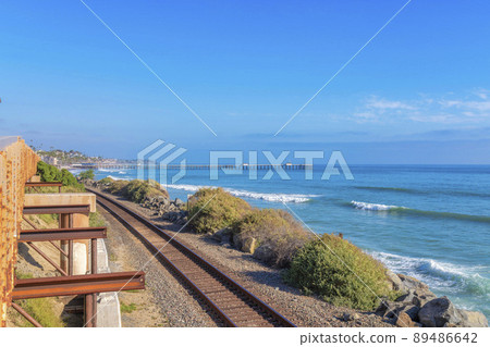 View of train tracks and beach with pier against the clear blue sky in San Clemente, California 89486642