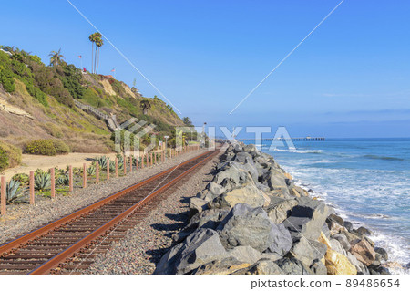 Train track near the beach at San Clemente, California with rock seawall 89486654