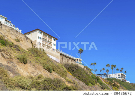 Slope with shrubs and palm trees near the neighborhood in San Clemente, California Slope with shrubs and palm trees near the neighborhood in San Clemente, California 89486672