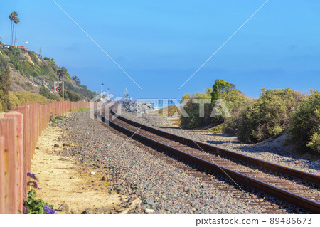 Train track in San Clemente, California with wooden posts barrier on the left 89486673
