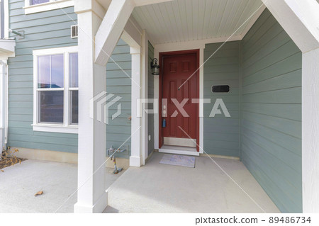 Townhouse porch with lockbox on the red front door 89486734