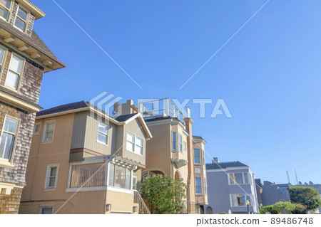 Facade of houses with different wall sidings in a low angle view in San Francisco, California 89486748