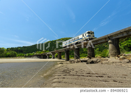 JR九州地方線日南線Kiha 40在宮崎縣日南市山王的熊谷川橋上行駛，在日南海岸上鋪滿湛藍的天空 89486921