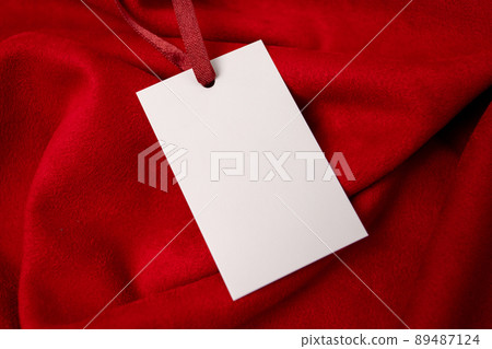 Modern advertising for cloth design. Clothes tag mock up white on red fabric. Modern design. Red fabric pattern background. Price tag. Modern advertising for cloth design. Clothes tag mock up white on red fabric. Modern design. Red fabric pattern background. Price tag. 89487124