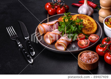 Slices of delicious raw or salted bacon with spices, salt, vegetables and herbs on a wooden cutting board 89487409