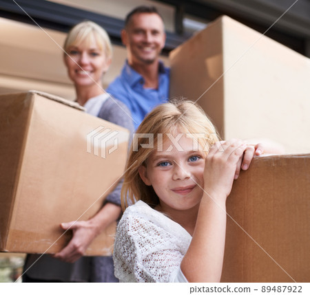 Were going to our new house. A family of three carrying boxes into their new home. Were going to our new house. A family of three carrying boxes into their new home. 89487922