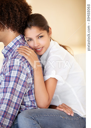 Ive found my soulmate. Studio shot of a young ethnic woman leaning on her boyfriend while they sit on the couch together. 89488068