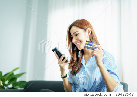 Online Shopping and Internet Payments, Portrait of Asian woman are using their mobile phones and credit cards to shop online or conduct errands in the digital world Online Shopping and Internet Payments, Portrait of Asian woman are using their mobile phones and credit cards to shop online or conduct errands in the digital world 89488548