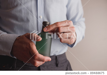 Man in formal wear holding perfume bottle, closeup. Space for text. Man in formal wear holding perfume bottle, closeup. Space for text. 89488675