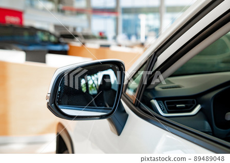 the side mirror on the white car. official dealerships and auto shops. the side mirror on the white car. official dealerships and auto shops. 89489048