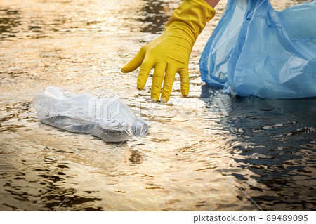 Collect garbage beach. Cleaning trash beach waste plastic PET bottle plastic pollution. Volunteer cleaning river trash pick up litter picking. Picking up garbage water plastic nature. Collecting trash Collect garbage beach. Cleaning trash beach waste plastic PET bottle plastic pollution. Volunteer cleaning river trash pick up litter picking. Picking up garbage water plastic nature. Collecting trash 89489095